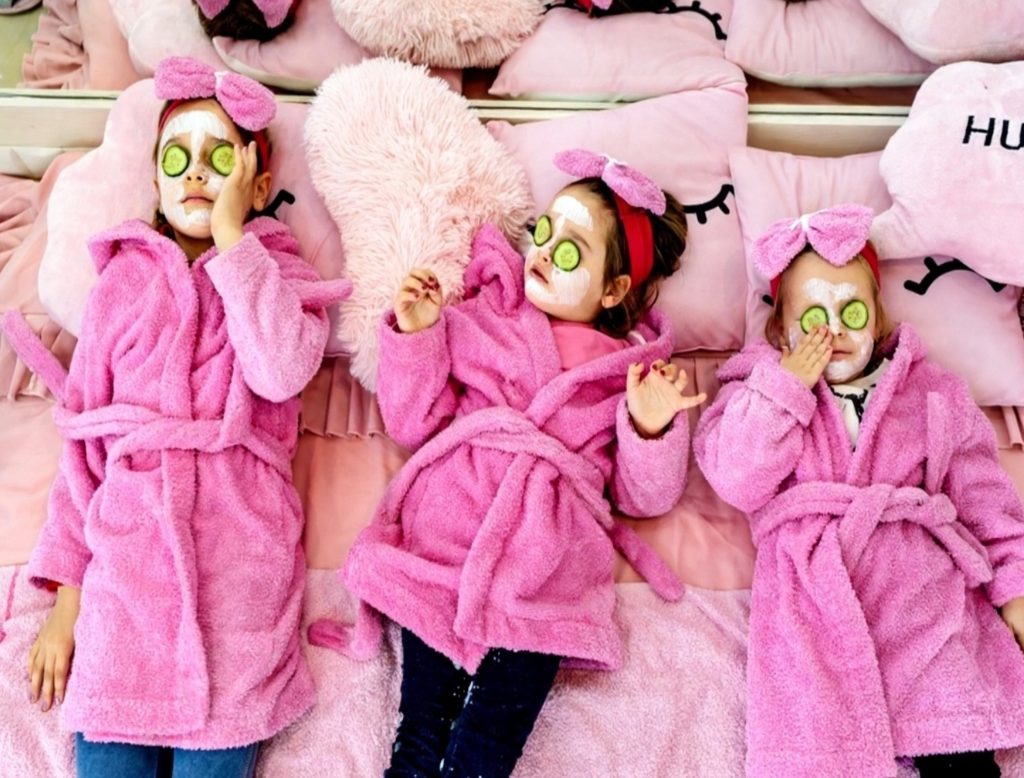 Three little girls enjoying a kids spa facial with cucumber masks at StarKids in Dubai