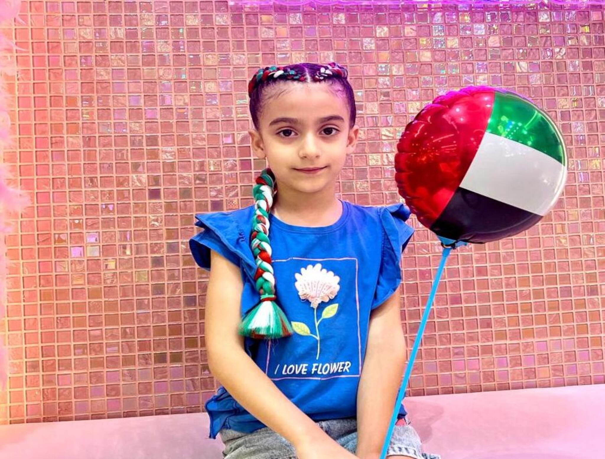 Girl with festive National Day-inspired hairstyle at StarKids Salon Dubai